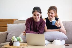 avslappnad ung asiatisk kvinna njuter avslappning på en bekväm soffa på Hem. de skön flicka lugnt slappnar av och andas färsk luft i de hus. Kolla på bio och social nätverk. foto