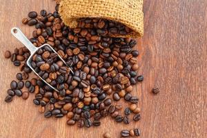 kaffebönor i säckar på en brun bakgrund foto