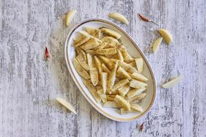 en trä- bricka med frites och ketchup foto