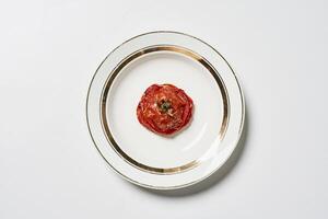 en tallrik med en tomat på den foto