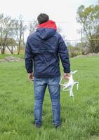 en man med en quadrocopter i hans händer. vit kvadrokopter prepa foto