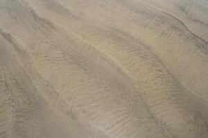 en sand dyn med vågor på den foto