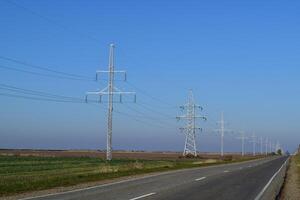 Stöd av elektricitet kablar längs de väg foto