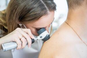 läkare hudläkare undersöker hud av patient. dermatoskopi, förebyggande av melanom, hud cancer. hög kvalitet Foto