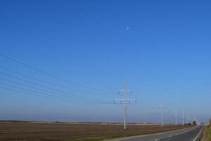 Stöd av elektricitet kablar längs de väg foto