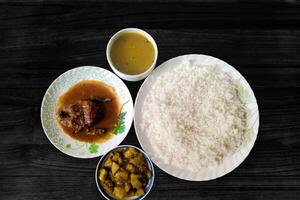 bäst lunch i indisk bengali med enkel ris, rui fisk curry, vegetabiliska curry, och dal. studerande allmänning lunch i en hotell och restaurang. friska mat tallrik foto