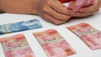 en man räknas indonesiska rupiah pengar. finansiell förvaltning begrepp foto