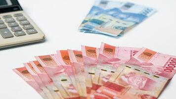 samling av rupiah valuta och kalkylator på en vit bakgrund foto