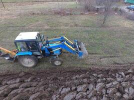 traktor plöjning de trädgård. plöjning de jord i de trädgård foto