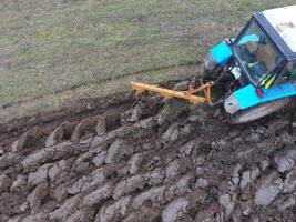 traktor plöjning de trädgård. plöjning de jord i de trädgård foto