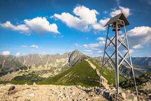 klocktorn i berg. en enkel klocktorn på de topp av kasprowy wierch i tatra bergen i polen. foto