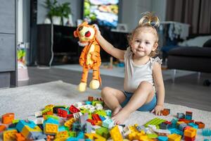 caucasian barn en liten flicka är spelar i de konstruktör på Hem. pedagogisk leksaker för barn. foto