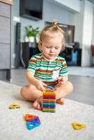 liten flicka spelar färgrik magnet plast block utrustning på Hem. de barn spelar pedagogisk spel. tidigt barndom utveckling. foto