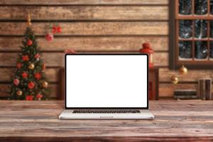 laptop mockup i jultomten trästuga med juldekorationer. isolerad skärm för julhälsning text eller webbdesign marknadsföring foto