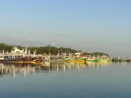 färgrik fiske båtar förankrade i de hamn på paiton strand indonesien foto