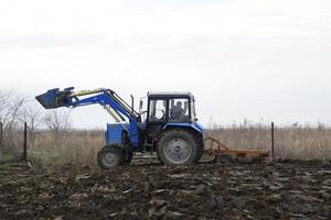 traktor plöjning de trädgård. plöjning de jord i de trädgård foto