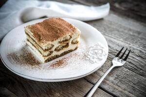 tiramisu i de tallrik på de trä- bakgrund foto