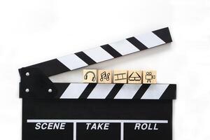 clapperboard eller film skiffer svart Färg på vit bakgrund och olika underhållning ikoner på trä- block. bio industri, video produktion och filma begrepp. foto