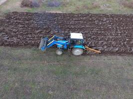 traktor plöjning de trädgård. plöjning de jord i de trädgård foto