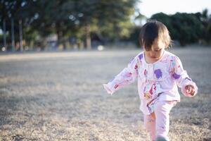 liten flicka njuter utomhus- sporter aktiviteter. foto