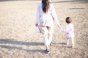 mor och dotter spelar och löpning runt om de parkera på skön morgon. foto