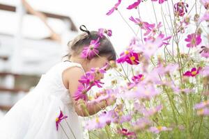 kvinna händer Rör blommor på bakgrund med skön blommor och grön löv i de trädgård. kvinnors händer Rör och njut av de skönhet av en naturlig asiatisk blomma trädgård. foto