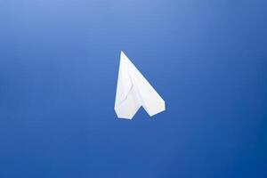 vit papper flygplan på en blå himmel bakgrund. de symbol av frihet och Integritet på de internet foto