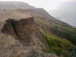 de kuperad kust nära de hav av azov. lera stenar, en klippa på de Strand foto