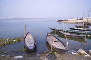 landskap se av några trä- fiske båtar på de Strand av de padma flod i bangladesh foto