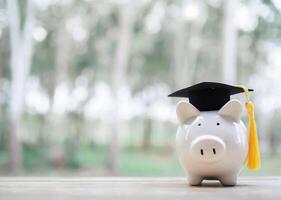 nasse Bank med gradering hatt. de begrepp av sparande pengar för utbildning, studerande lån, stipendium, undervisning avgifter i framtida foto
