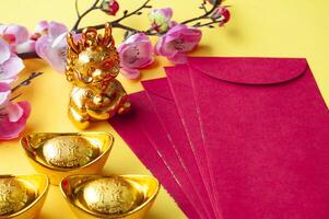 topp se av kinesisk ny år röd paket, körsbär blomma och gyllene göt dekoration. kopia Plats. foto