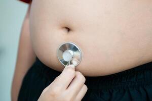 stetoskop begrepp av fett barn med mage foto
