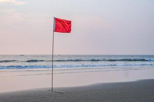 röd flagga på strand på hav eller hav som en symbol av fara. de hav stat är anses vara farlig och simning är förbjuden. foto