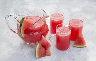 färsk röd vattenmelon dryck på varm sommar dag på ljus grå cement bakgrund foto