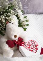 hjärtans dag gåva, teddy Björn med en hjärta, en låda av praliner och en bukett foto