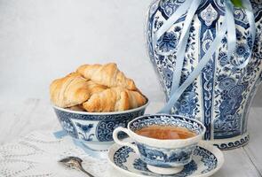 delikat vår fortfarande liv med croissanter och en bukett av rosa pioner foto