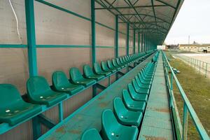 rader av säten i ett tömma stadion. grön säten på de stadion foto