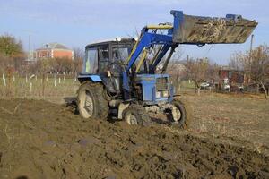 traktor plöjning de trädgård. plöjning de jord i de trädgård foto