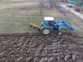 traktor plöjning de trädgård. plöjning de jord i de trädgård foto