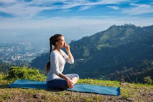 kvinna praxis pranayama i lotus utgör utomhus foto