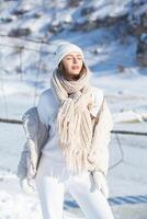 porträtt av en skön ung kvinna i vit vinter- kläder på natur foto