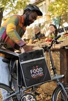 färsk producera leverans. ung afrikansk manlig kurir plockning upp beställa med friska organisk mat från lokal- jordbrukare marknadsföra, leverera egenodlad frukt och grönsaker till kunder foto