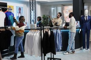 kassör och kund interagera på Kläder Lagra disken skrivbord. afrikansk amerikan man uppköp tillfällig trendig kläder och stående på kontanter Registrera i handla köpcenter boutique foto