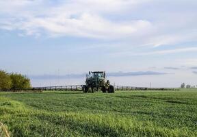 traktor med en spray enhet för fint spridda gödningsmedel. foto