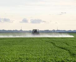 traktor med en spray enhet för fint spridda gödningsmedel. foto