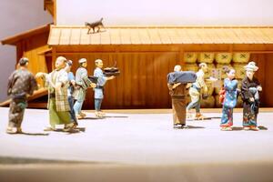 Osaka, Japan, 2023- miniatyr- modeller och leksaker i aktiviteter och dagligen liv av 1800-talet gammal japansk människor på urban väg i de stad. foto