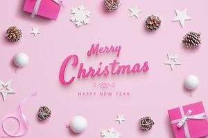 god jul och gott nytt år gratulationskort med juldekorationer på rosa pastellyta. ovanifrån, platt låg foto