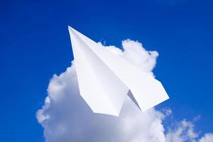 vit papper flygplan i en blå himmel med moln. de meddelande symbol i de budbärare foto