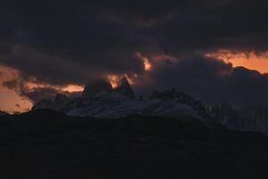 montera fitz roy, cerro torre och el chalten stad på kväll skymning. rosa moln. kullar och snötäckt berg. anderna, patagonien foto