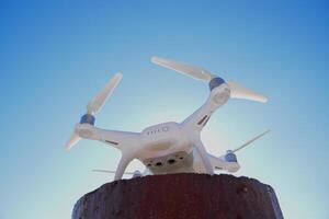 quadrocopter Spöke 4 mot de blå himmel i de Sol. bakgrundsbelysning. dron är ett innovativ flygande robot. foto